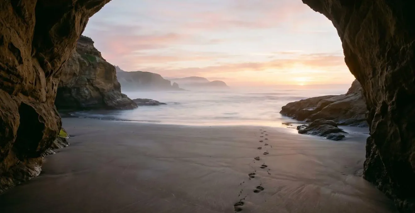 Secluded rocky cove with golden dawn light illuminating calm waters between sandstone cliffs
